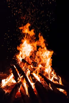 Campfire with flying sparks isolated on black background