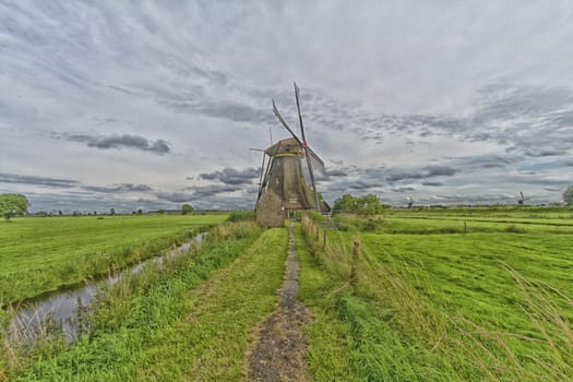 Windmill near the water canal at sunrise in Netherlands