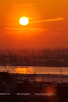 Hot orange sunset over the river. Urban landscape