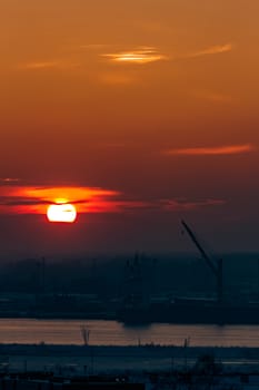 Hot orange sunset over the river. Urban landscape