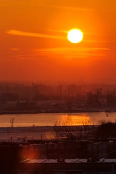 Hot orange sunset over the river. Urban landscape