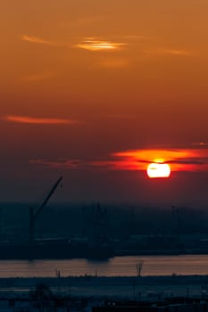 Hot orange sunset over the river. Urban landscape