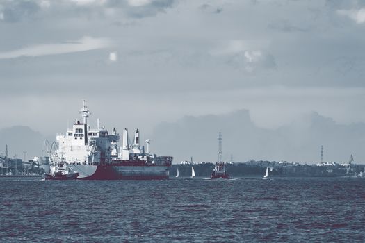 Cargo ship and the tug ship towing it to the port