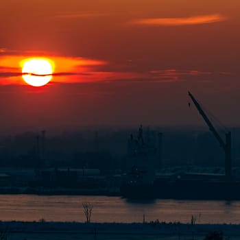 Hot orange sunset over the river. Urban landscape