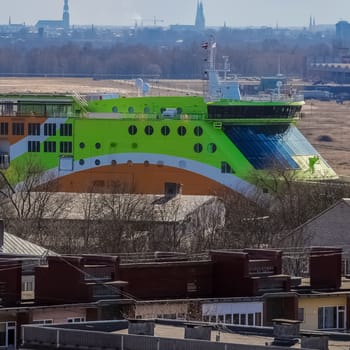 Green cruise liner. Passenger ferry sailing past the Riga city