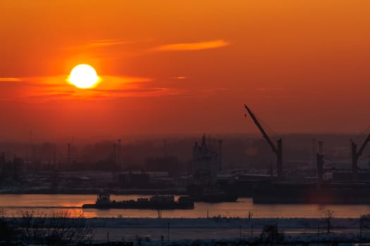 Hot orange sunset over the river. Urban landscape