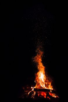 Campfire with flying sparks isolated on black background