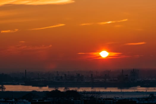 Hot orange sunset over the river. Urban landscape