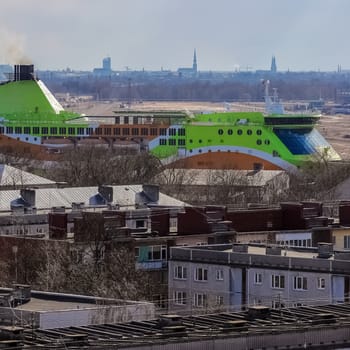 Green cruise liner. Passenger ferry sailing past the Riga city