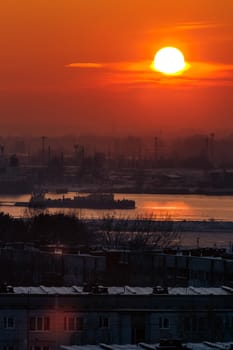 Hot orange sunset over the river. Urban landscape