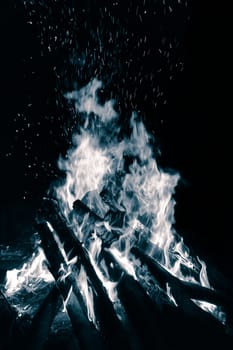 Blue bonfire with flying sparks isolated on black