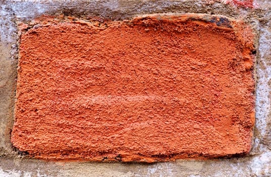 Surface of red brick embedded into the wall - in close-up.