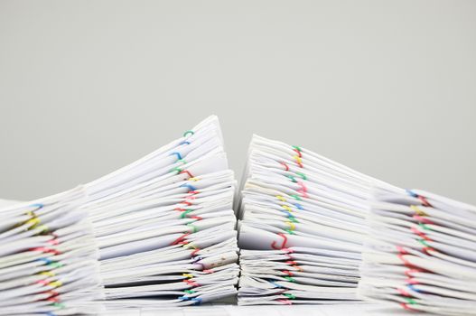 Pile overload document of receipt and report with colorful paperclip on finance account have blur pile paperwork on foreground with white background.