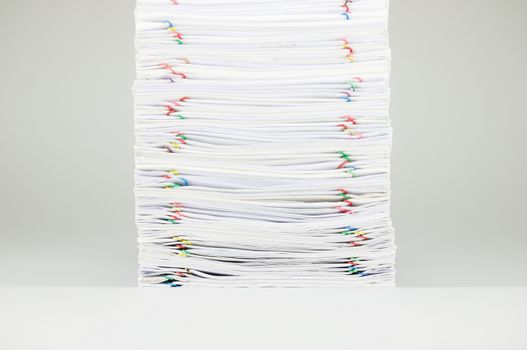 Pile overload document of receipt and report with colorful paperclip on white background.