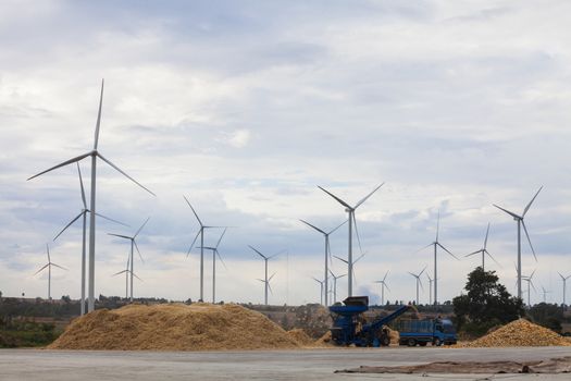  Corn sorting machine is working and Wind power generators in the field against blue sky