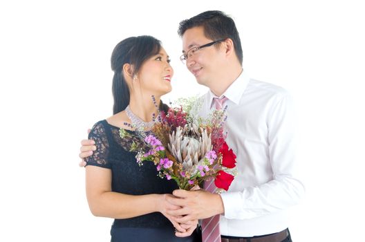 Portrait of young elegant enamoured just married groom and bride embracing at Wedding on white background