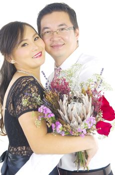 Portrait of young elegant enamoured just married groom and bride embracing at Wedding on white background