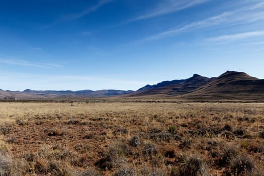 Graaff-Reinet with yellow fields and  mountains with blue sky in South Africa.