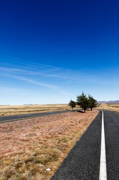 The two Long roads leading to the mountains with blue sky.