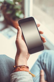 Mobile phone in the hands of a girl with screen