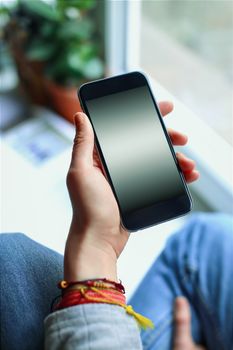 Mobile phone in the hands of a girl with screen