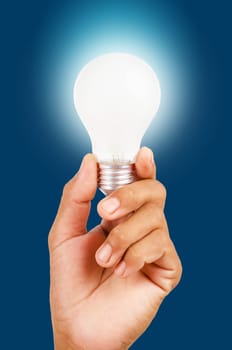 energy saving lamp in hand on blue background