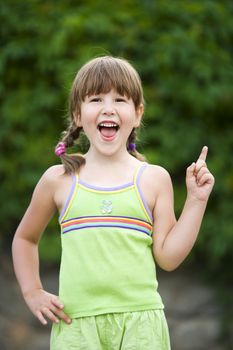 Happy five years Girl pointing up smiling outdoors