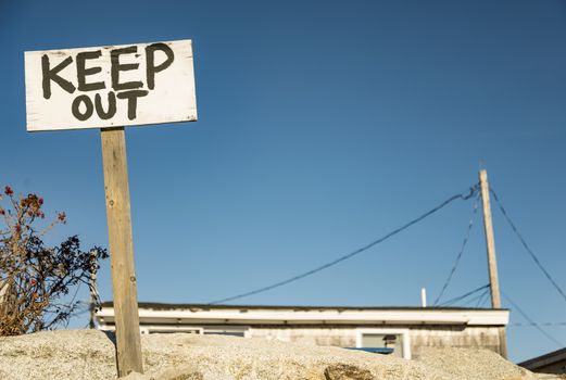 Black and white keep out sign on a small post