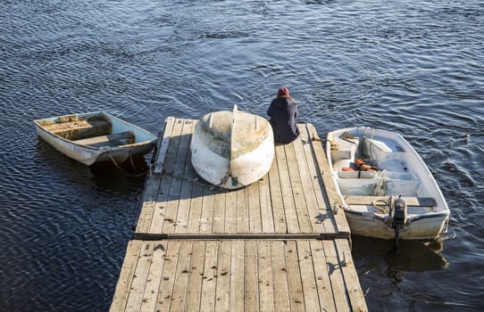 boats and a person on the ocean pier in Maine, USA