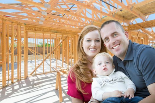 Young Military Family Inside The Framing of Their New Home at Construction Site.