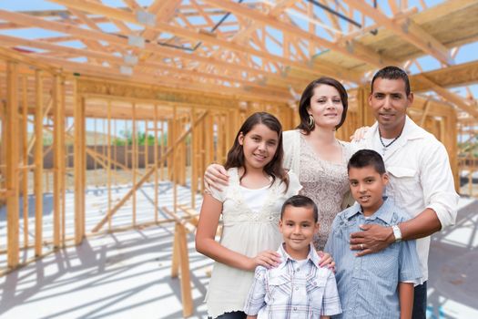 Young Hispanic Family On Site Inside New Home Construction Framing.
