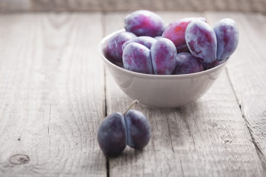 A bunch of Plums on a wooden table