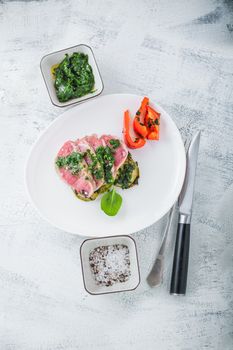 A plate of sliced roast beef, zucchini and salsa verde