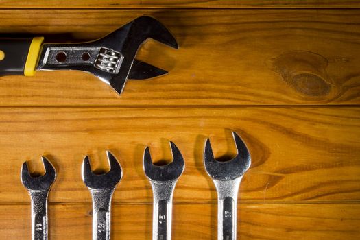 Adjustable wrench and wrenches on a wooden background