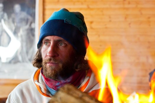 A man with long hair near a fire