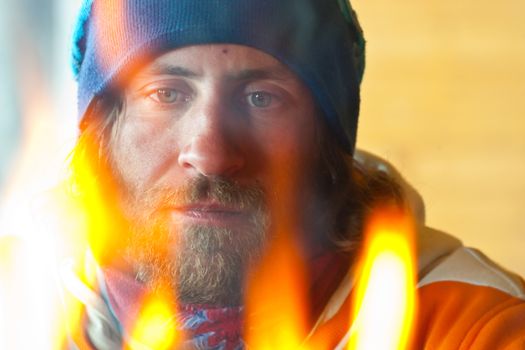 A man with long hair near a fire