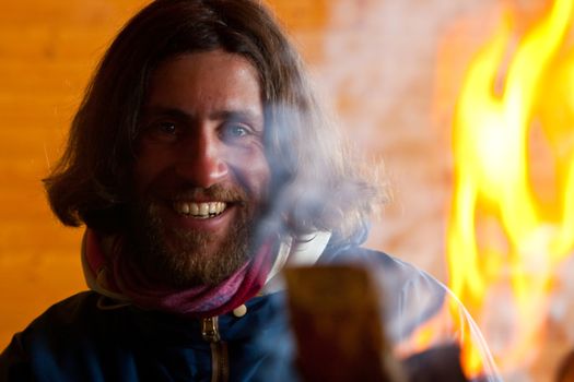 A man with long hair near a fire