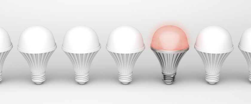 One unique glowing light bulb among others on white background
