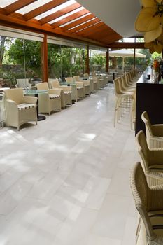 Bar with stools and tables under a veranda in a hotel