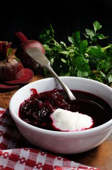 A dish of beet soup with sour cream. Vertical shot.