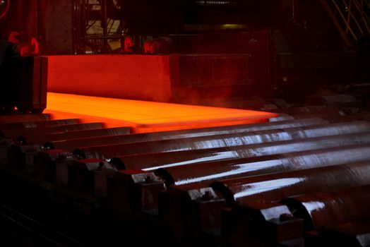 Hot steel plate on conveyor inside of steel plant