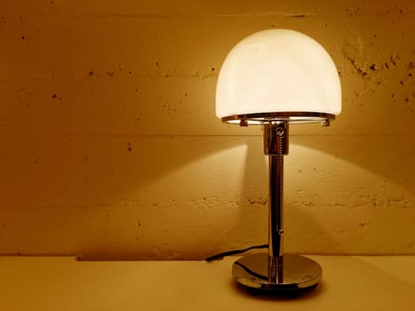 Table lamp giving warm orange light. Contemporary design.