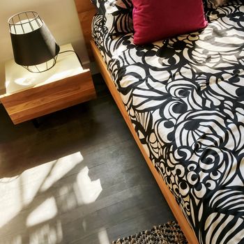 Bright cozy bedroom in sunlight. Stylish home decor.