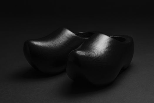 Two traditional Dutch black wooden shoes in a low key recording
