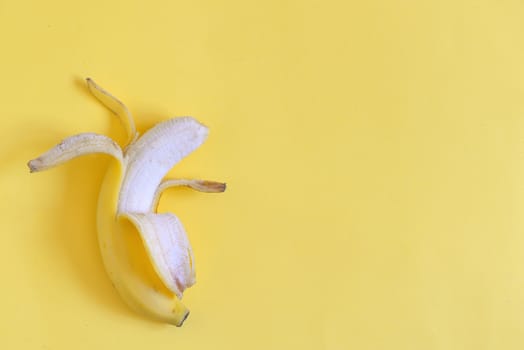 Ripe open banana on yellow background