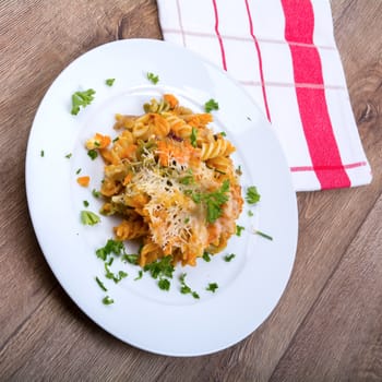 Vegetarian food on a white plate with wooden background