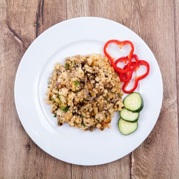 Vegetarian food on a white plate with wooden background