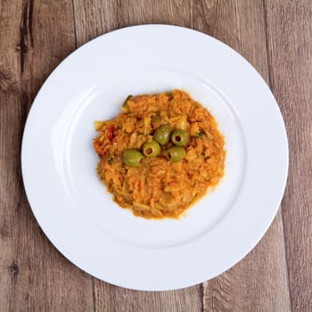 Vegetarian food on a white plate with wooden background