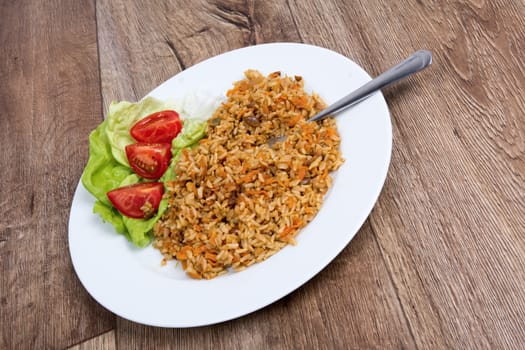 Vegetarian food on a white plate with wooden background