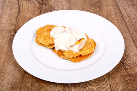 Vegetarian food on a white plate with wooden background